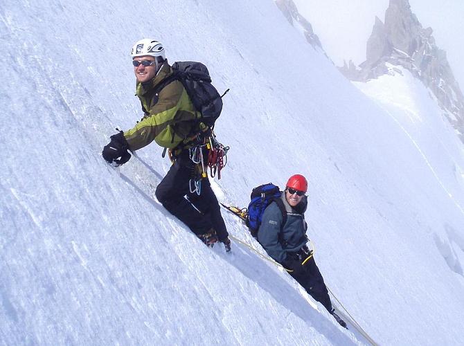 Climbing a steep snow slope, with the belayer using a bucket seat belay.
